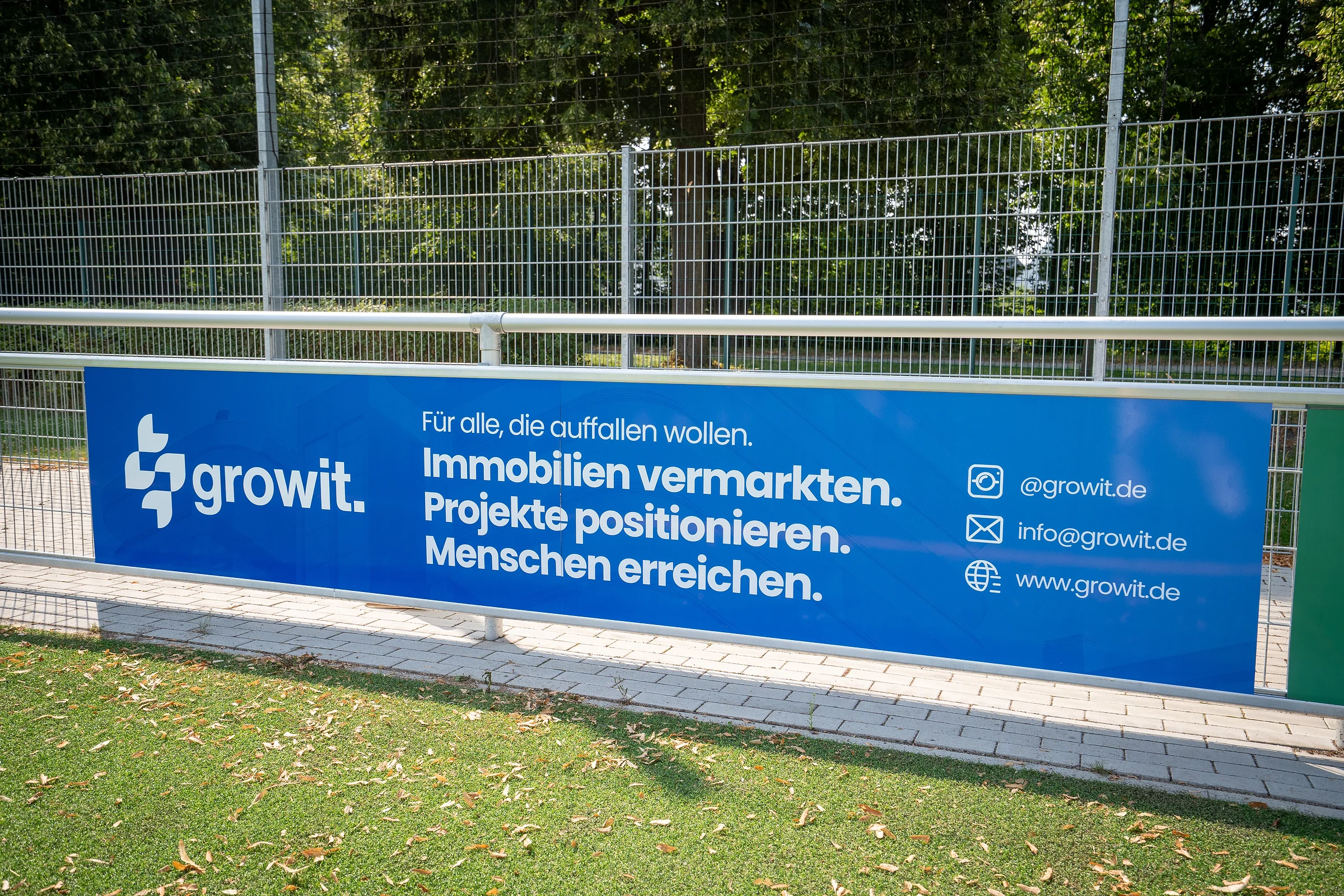 Growit-Banner an der Bande eines Sportplatzes
